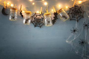 Halloween holiday concept. Masson jars with spiders, baths and wooden decorations