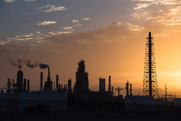 Silhouette oil refinery at sunrise. Oil factory, petrochemical plant tower, gas flare, smoke stacks...