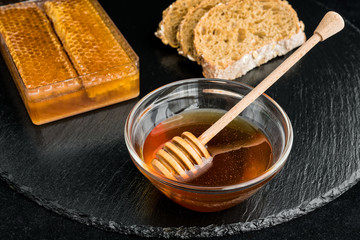 Honey and honeycomb on black dish