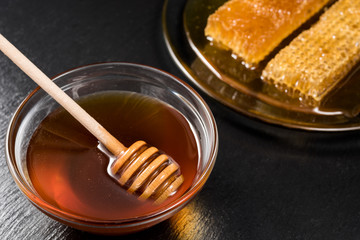 Honey and honeycomb on black dish