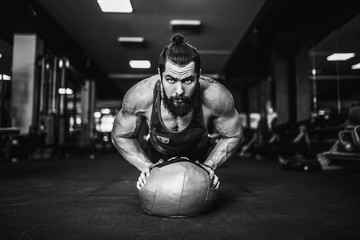 Plank it Confident muscled young man wearing sport wear and doing plank position while exercising on the floor in loft interior