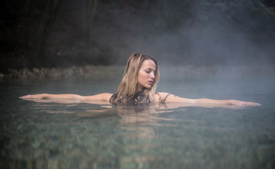 Fototapeta premium Young Woman Taking a Bath In Hot Spring Outdoor Maibachl Villach Austria