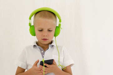 Cute little boy listening to music on a mobile device