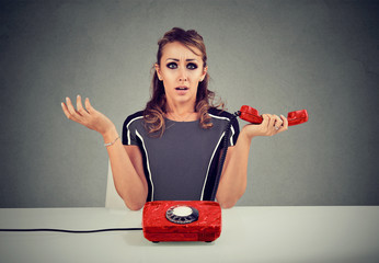 Shocked young woman receiving bad news on the phone - obrazy, fototapety, plakaty