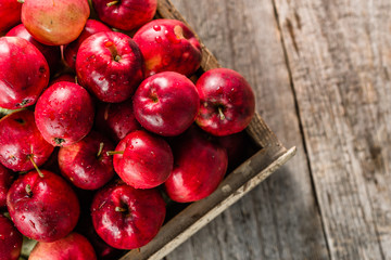 Fototapeta na wymiar Red apples on table, top view in wooden box, fresh apple fruits on farmer market