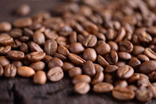Coffee beans on an old wooden desk. Top view with a copy space for your text. Macro photo of coffee beens.
