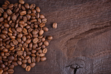 Coffee beans on an old wooden desk. Top view with a copy space for your text. Arabic and robusta coffee  background.