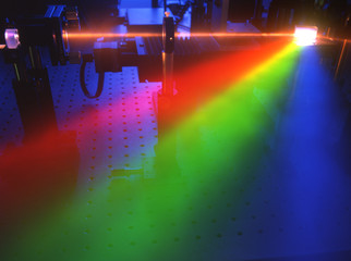 Laserstrahl beugt sich am Prisma in die Spektralfarben