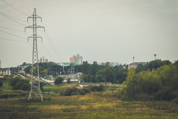 City landscape with electric poles and a river
