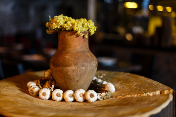 decor, clay pot with yellow flowers stands on a stump