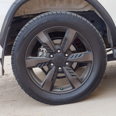 Obraz premium the wheel of the white car in the Parking lot close-up