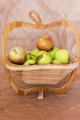 Green and red apples in a wooden vase
