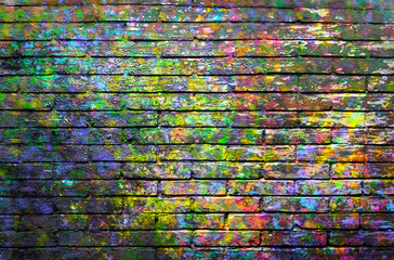 Brick wall painted with spots of paint colors 
