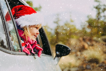 christmas car travel- happy little girl loves travel in winter
