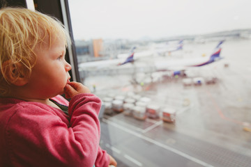 where to go next, travel concept- baby thinking looking at planes