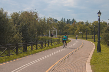 City recreation park with benches, lanterns and bicycle path
