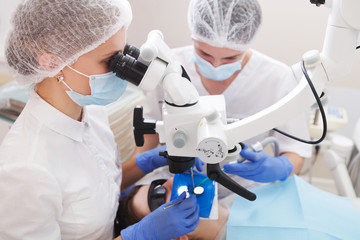 professional dentist examination patient with microscope at the office - obrazy, fototapety, plakaty