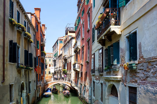 VENICE,ITALY- May 18, 2017. Tourists on water street with Gondola in Venice. its entirety is listed as a World Heritage Site, along with its lagoon