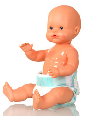 A sitting baby doll in diaper is isolated in white.
