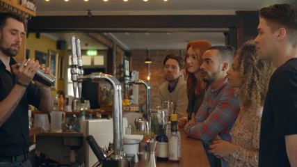 Bartender Giving Cocktail Making Demonstration In Bar