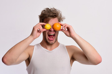 Athlete with messy hair holds fresh fruit. Man with fruit