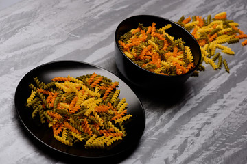 delicious colorful italian pasta in two balck ceramic plate