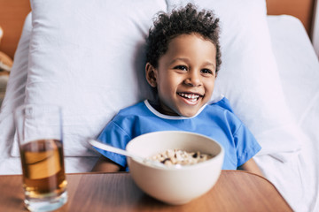 african american boy with breakfast in clinic