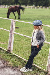 child at paddock with horse