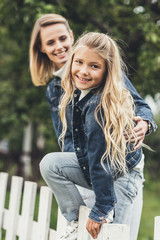 Fototapeta premium mother and daughter on fence