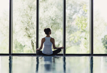 Woman meditating indoors. Girl practicing yoga