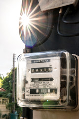 Power meter is attached to a power pole with beautiful light rays.