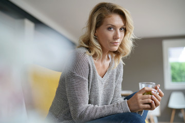 Beautiful woman relaxing in armchair with hot drink