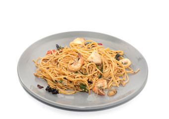 spaghetti with seafood on plate isolated on white background