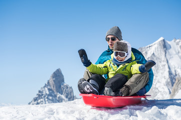 Fototapeta na wymiar Father with son sledding