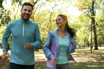 Young couple running together in park. Young people exercising.