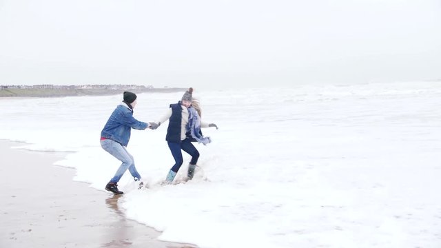 Young Couple Laughing In The Sea In Winter