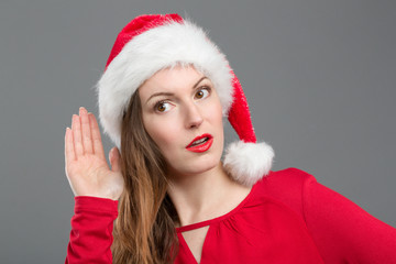 Frau mit Weihnachtsmütze hört genau hin