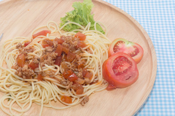 spaghetti with sauce on wooden plate