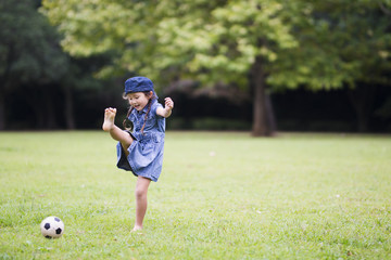 Happy Little Girl Kicking Soccer Ball