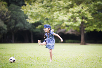 Happy Little Girl Kicking Soccer Ball