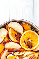 preparation of mulled wine in pot wooden background top view