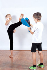 Fototapeta premium Girl and boy are training blow leg on the simulator