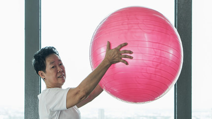 Fototapeta premium Asian senior old healthy woman exercise with pink gymnastic ball