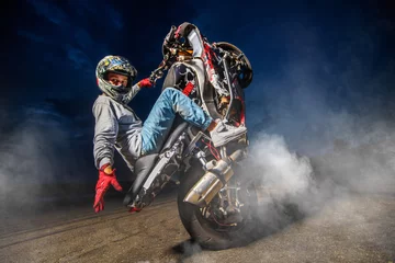Foto op Plexiglas Moto rider making a stunt on his motorbike. Biker doing a difficult and dangerous stunt. © Alex