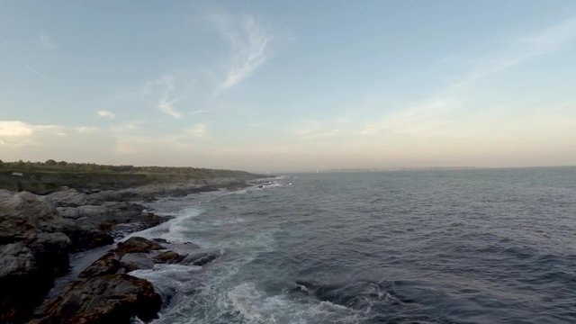 Aerial footage of rocky beach in Beavertail, Rhode Island at sunset.