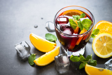 Sangria with fruit mint and ice on black slate.