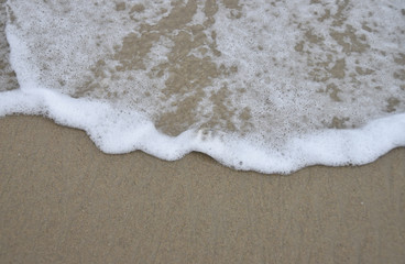 Water foam from wave on sand