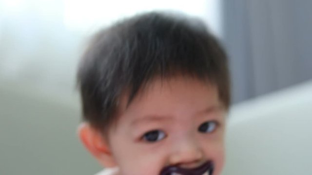 asian kid baby sucking nipple pacifier fancy vampire teeth dracula monster in halloween celebration party