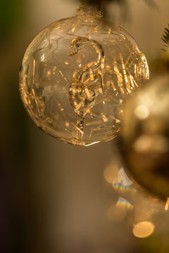 Christmas bauble with swan figurine insude on the spruce tree. Close-Up