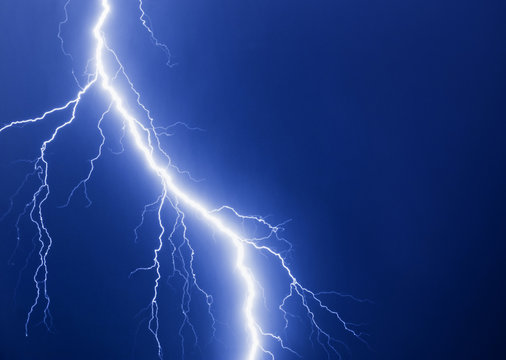 Lightning thunder bolt at blue background.